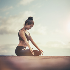 stock-photo-66140553-young-woman-meditating-outdoors-on-a-rooftop-at-sunset